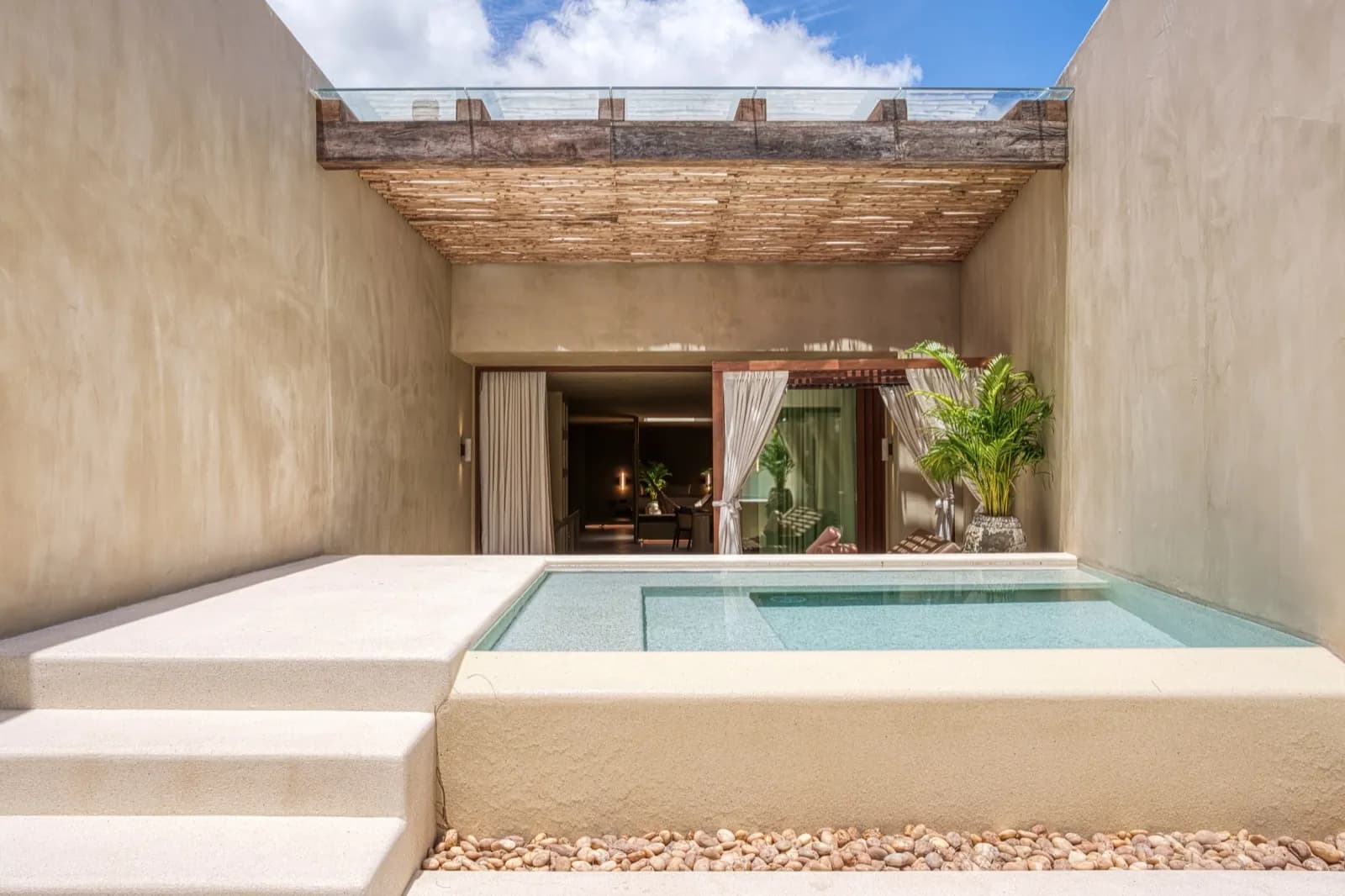 Raised plunge pool with wide steps in a minimalist walled courtyard