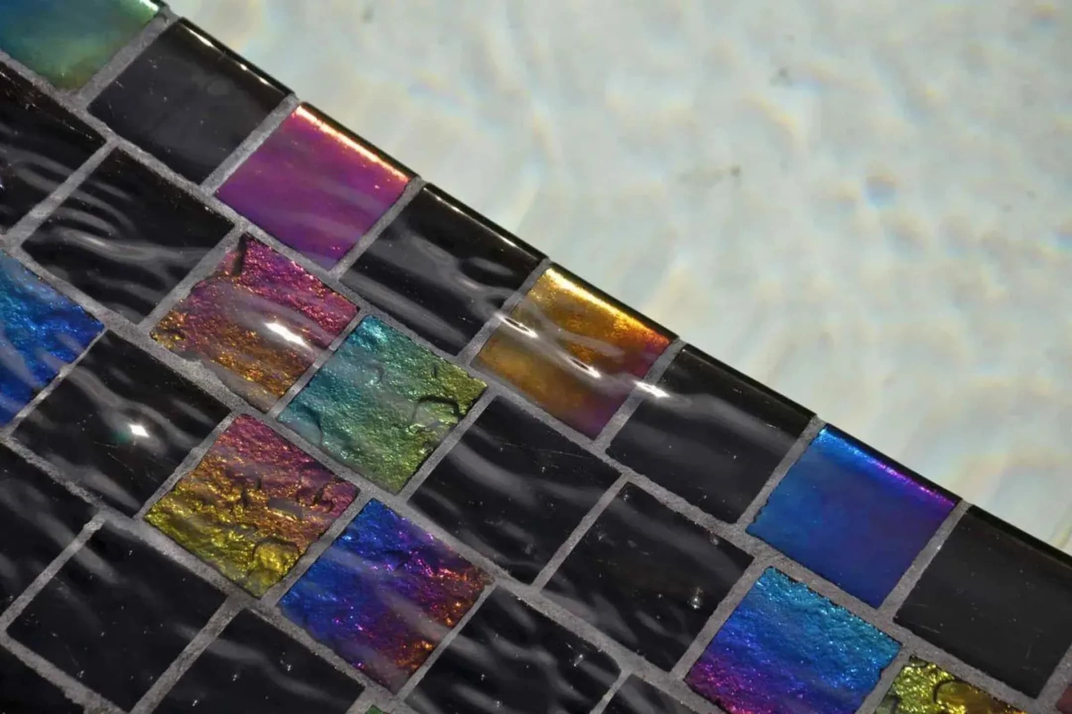 Close-up of black and rainbow iridescent Lightstreams tiles under water
