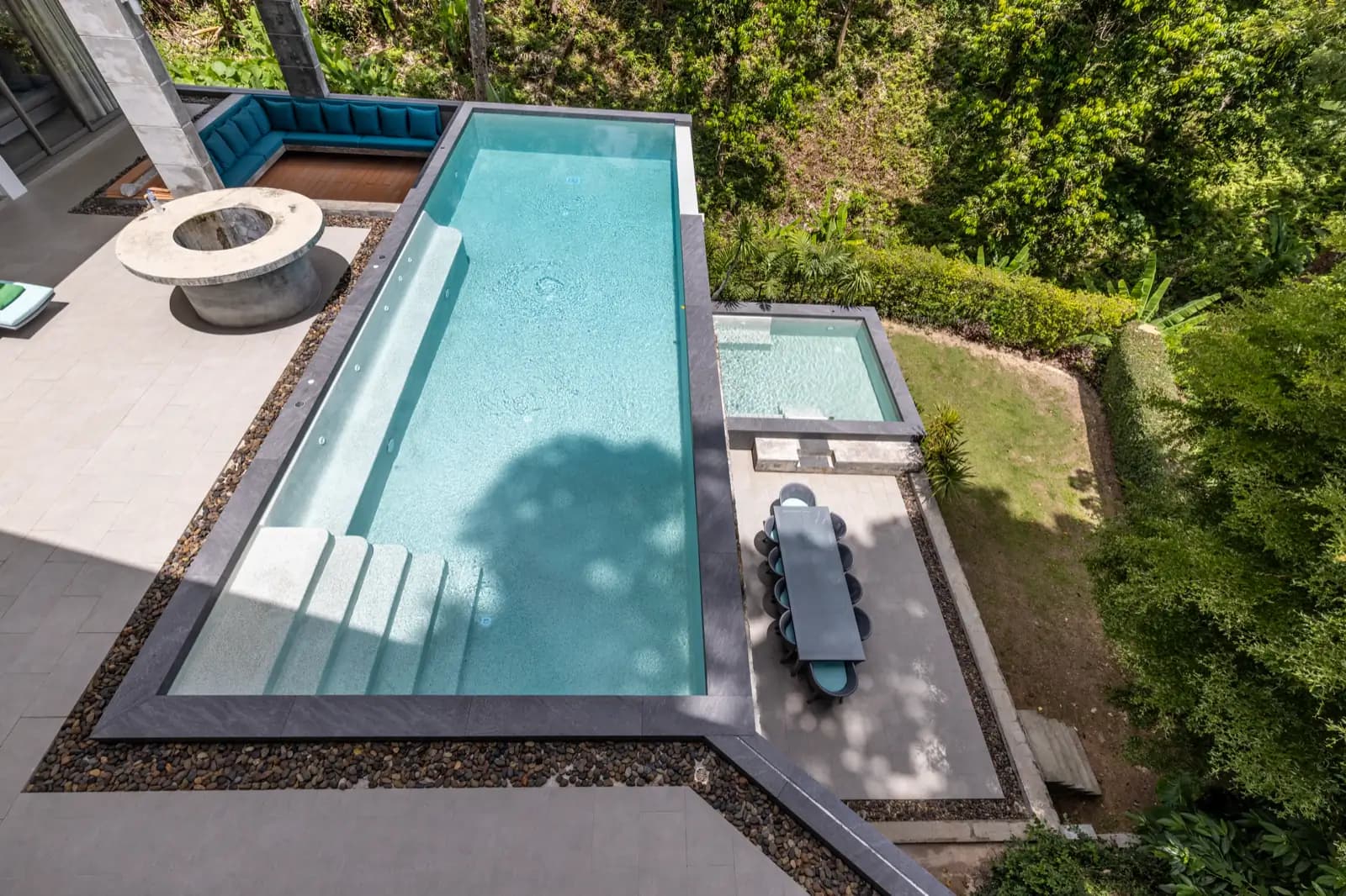 Long lap pool with built-in bench seen from the upper terrace