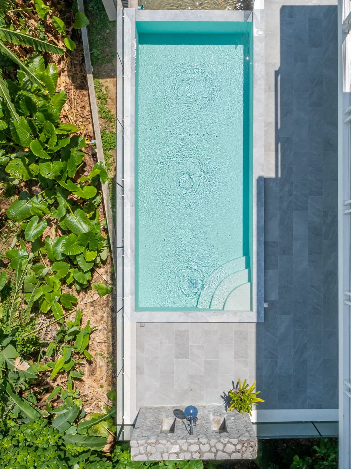Overhead view of a slim lap pool set into a hillside terrace