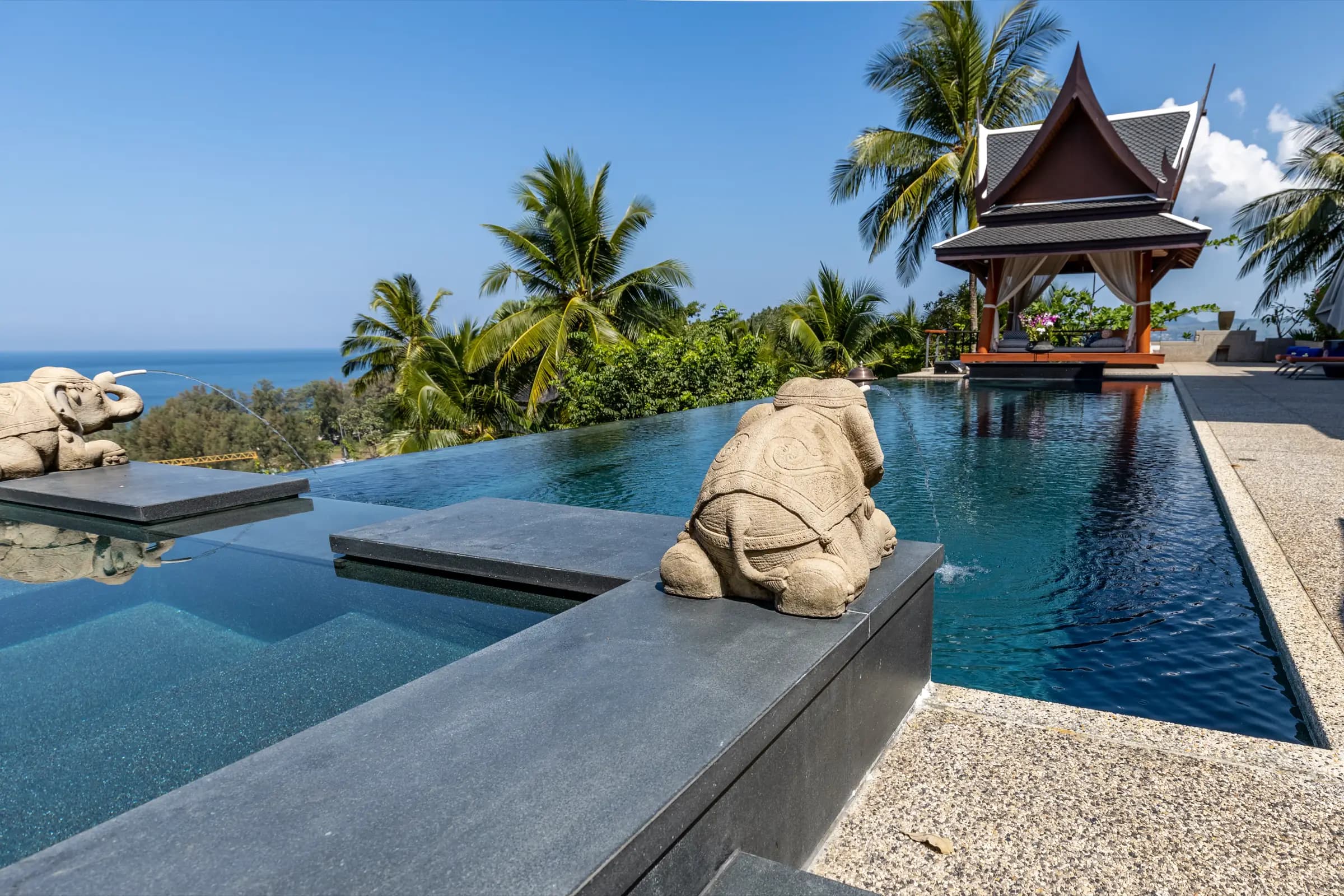 Infinity-edge pool with stone elephant fountains overlooking the Andaman Sea