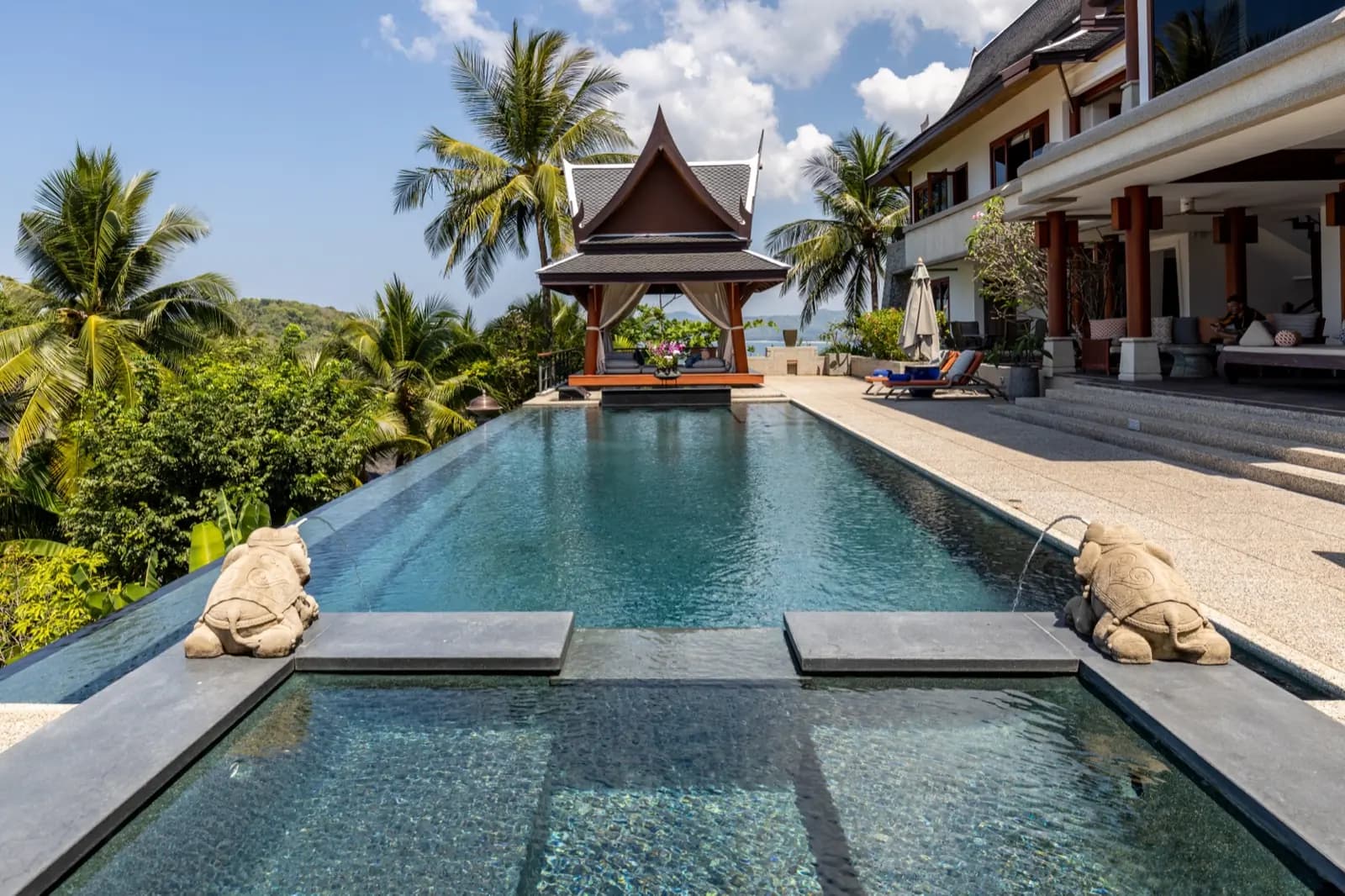 Stepping-stone pads across a dark pool toward the Thai sala