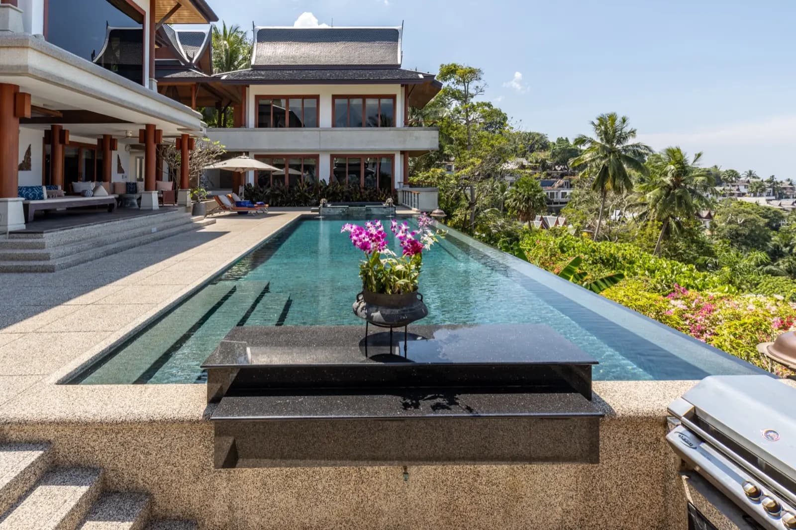 Granite pool bar with orchids beside the long dark pool